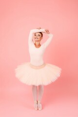 Smiling ballerina dancing indoors