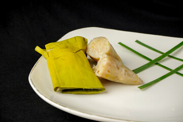 A snack made from bananas and mixed with flour and coconut milk, then wrapped in banana leaves and then steamed.