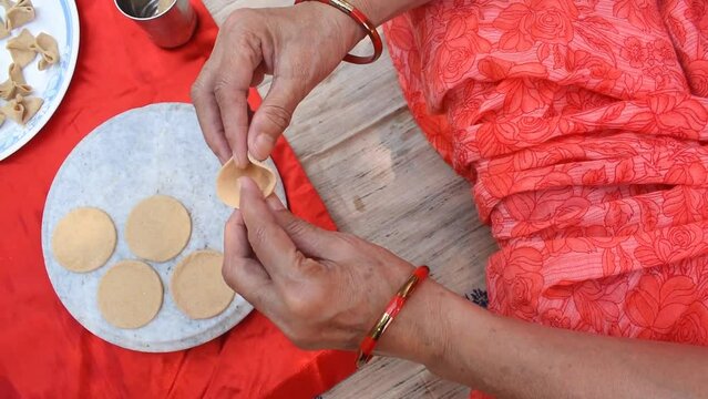 flower shaping of raw Dal pithi of Bihar, Dal Dhokli of gujarat, Varan Phal of Rajasthan, Chakolya of Maharashtra in white plate red background. Dish made by simmering wheat flour dumpling in dal.