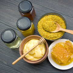 Fresh flower honey of different varieties, pollen and honeycomb with spoons on a wooden background. Organic Vitamin Health Food