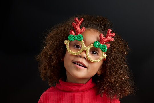 Little girl with afro hair wearing Christmas party glasses