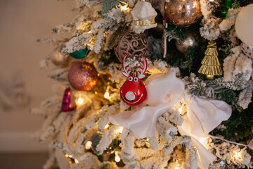 White Christmas tree with vintage toys, Reindeer Rudolph, balls, garlands on a spruce branches with artificial snow, copy space