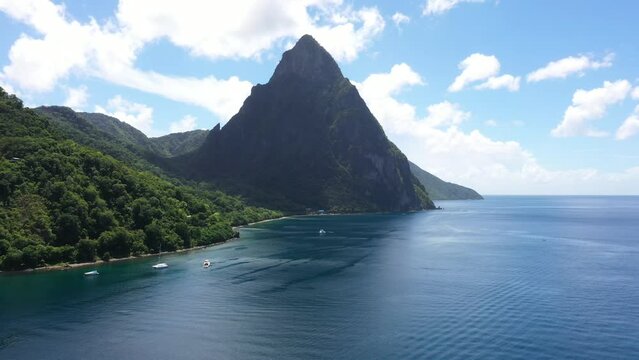 Soufriere, Saint Lucia - 10-16-2022: Push-in drone tilting up over the Soufriere Bay to reveal the Petit Piton.