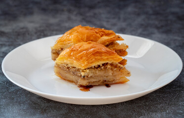Walnut baklava in a white plate. Turkish style walnut baklava presentation and service. Horizontal view.