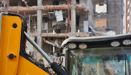 Excavators on a demolition site with skyscrapers in the background. Old building being demolished...