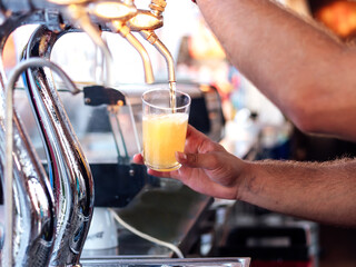 Man pouring beer into a glass with a beer puller