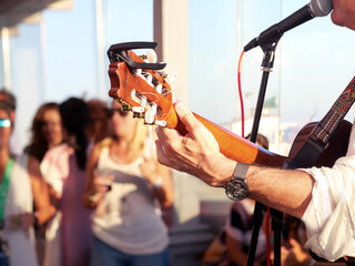 Close-up of man singing and playing guitar at a party.