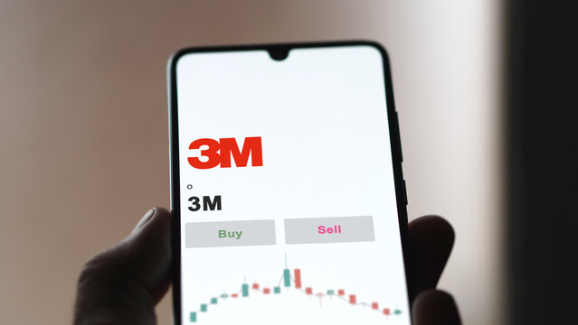 September 13th 2022, New York. An investor's analyzing the 3M MMM stock on screen. A phone shows the prices to invest