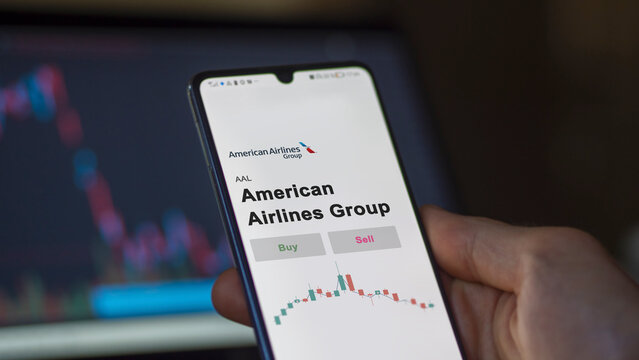 September 13th 2022, New York. An investor's analyzing the American Airlines Group AAL stock on screen. A phone shows the prices to invest