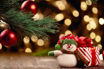 cheerful snowman and boxes with Christmas presents on a festive background.
