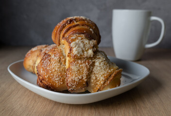 Fresh traditional polish pastry with poppy-seed filling and nuts. St. Martin's croissant. Rogal marciński or świętomarciński and white ceramic coffee cup or tea mug.