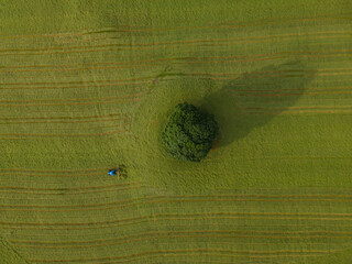 A drone shot of a tractor turning grass, Malham, UK