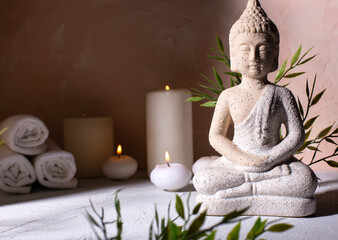 Spa beauty wellness concept with statue of Buddha  and with burning candles for spa time.  Religion concept.