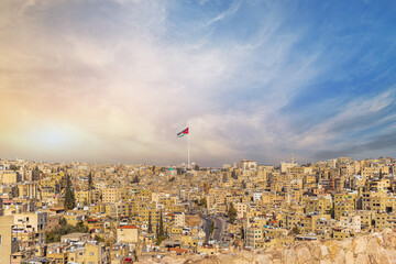 Jordan flag in Amman, panoramic view of cloudy sky background