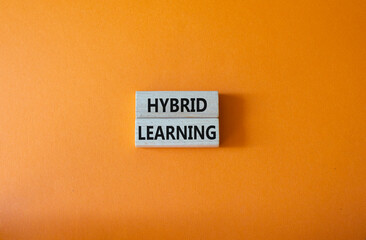 Hybrid learning symbol. Concept word Hybrid learning on wooden blocks. Beautiful orange background....
