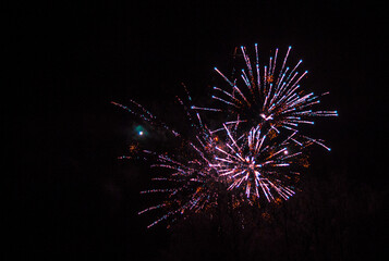 Huge fireworks explosions with Violet and golden colors over a party