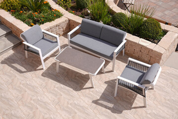 3 white and gray sofa and a table made of metal in courtyard and garden on the garden floor,...