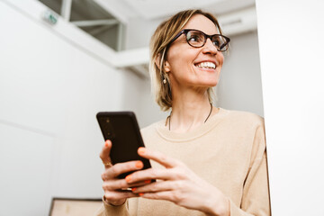 Young business woman with cell phone looks to the side