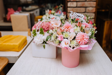 Cardboard baskets, boxes with colorful flowers are on a wooden table. Text, the word 