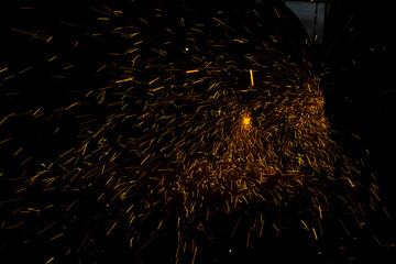 Lights in dark. Sparks from sawing metal. Industrial background.