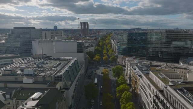Forwards fly above wide street with rows of trees. Modern buildings in urban borough. Charlottenburg neighbourhood, Berlin, Germany