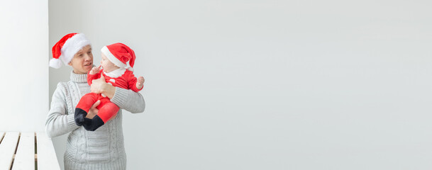 Banner fatherhood and holidays concept - Father with his baby boy wearing Santa hats celebrating Christmas copy space