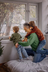 Dad and sons look out the window