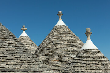 Fototapeta na wymiar Dächer von mehreren Trullo Häusern in Apulien, Italien