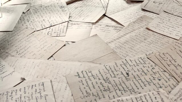 Table covered with many old letters. Left to right panoramic rotation with selective focus