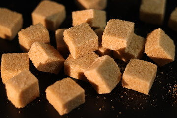Terrones de azúcar moreno en fondo negro