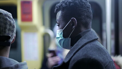 African man entering subway wagon wearing covid-19 face mask in underground metro 2