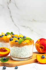 Healthy chia pudding with yogurt and fruit Peach and blueberry. Homemade dessert with fruits. place for text, top view