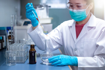 Chemical Advanced Research Laboratory, female scientist is adding reagent for the chemical preparation of the experiment in lab. Research for pharmaceutical, medicine, and biotechnology development.