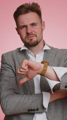 Dislike. Upset unhappy handsome business man showing thumbs down sign gesture, expressing discontent, disapproval, dissatisfied, dislike. Young adult guy. Indoor studio on pink background. Vertical