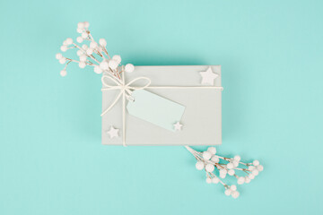 Present box with a blank tag, snow covered berries, christmas holiday wintertime
