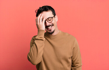 laughing and slapping forehead like saying d’oh! I forgot or that was a stupid mistake
