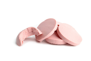 a pile of boiled sausage cut into slices and one bitten on a white background close-up