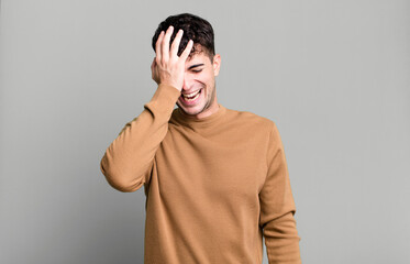 laughing and slapping forehead like saying d’oh! I forgot or that was a stupid mistake