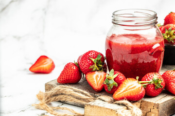 Jar of strawberry jam and fresh berries on white background. Homemade strawberry marmelade and fruit