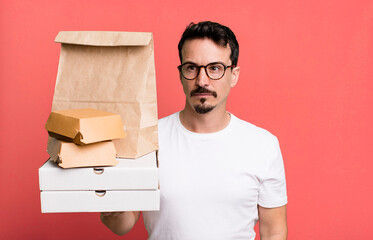 adult man feeling sad, upset or angry and looking to the side. fast food delivery and take away...