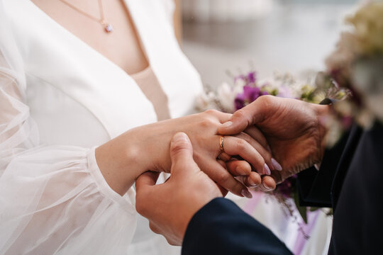 the groom puts on the ring to the bride, close-up exchange of rings