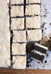 Chocolate layer sheet cake with white frosting and crumble topping cut into rectangle slices.  