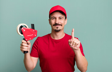 adult man smiling and looking friendly, showing number one. deliveryman packer concept