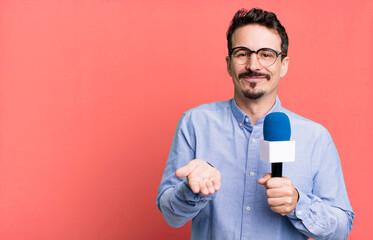 adult man smiling happily with friendly and  offering and showing a concept with a microphone....