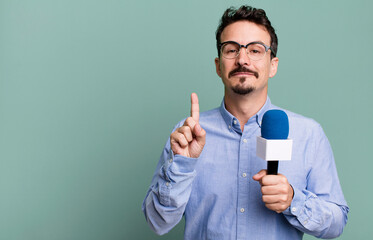 adult man smiling and looking friendly, showing number one with a microphone. presenter or...