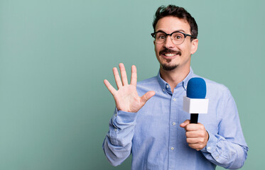 adult man smiling and looking friendly, showing number five with a microphone. presenter or...