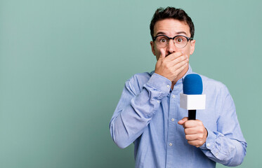 adult man covering mouth with hands with a shocked with a microphone. presenter or journalist...