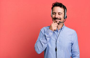 adult man smiling with a happy, confident expression with hand on chin with headset. telemarketer...