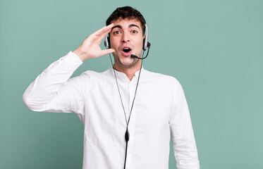 adult man looking happy, astonished and surprised with headset. telemarketer operator concept