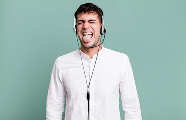 adult man with cheerful and rebellious attitude, joking and sticking tongue out with headset....
